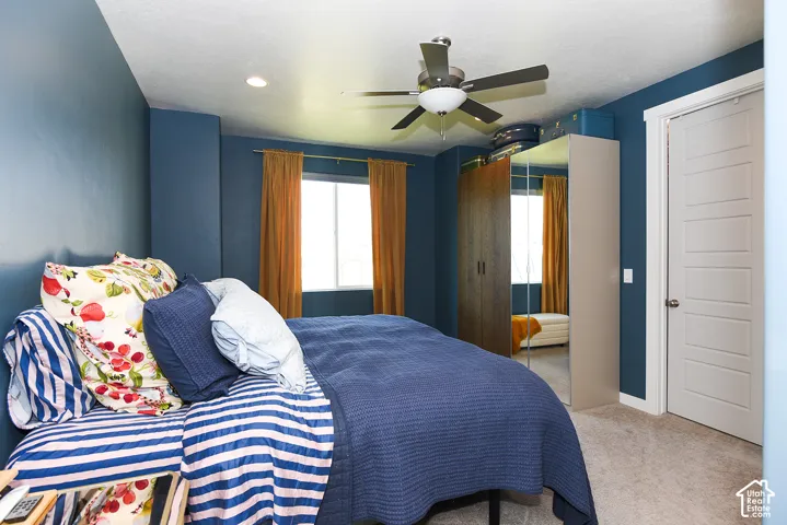Ceiling fan with integrated lighting, recessed lighting, double-pane window, paneled door, and carpeted flooring