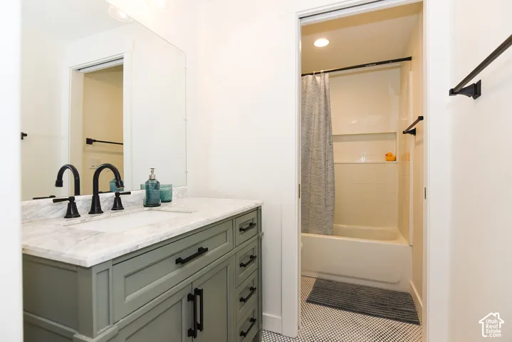 Vanity with a light-colored countertop, dual matte black faucets, and a recessed sink