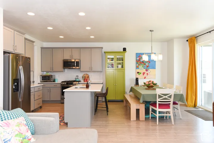 Kitchen with light-toned cabinetry, stainless steel appliances, recessed lighting, and a center island with a sink