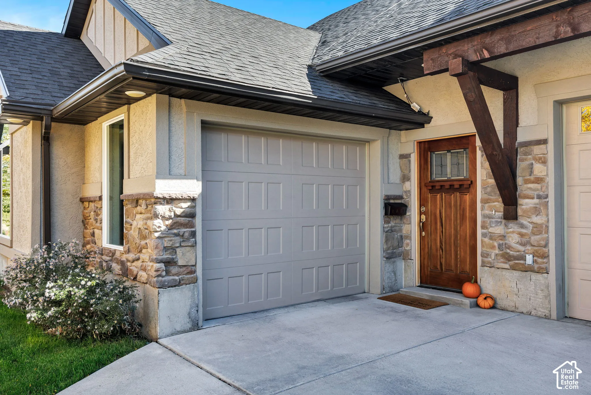 Stone veneer and stucco exterior with a durable shingle roof