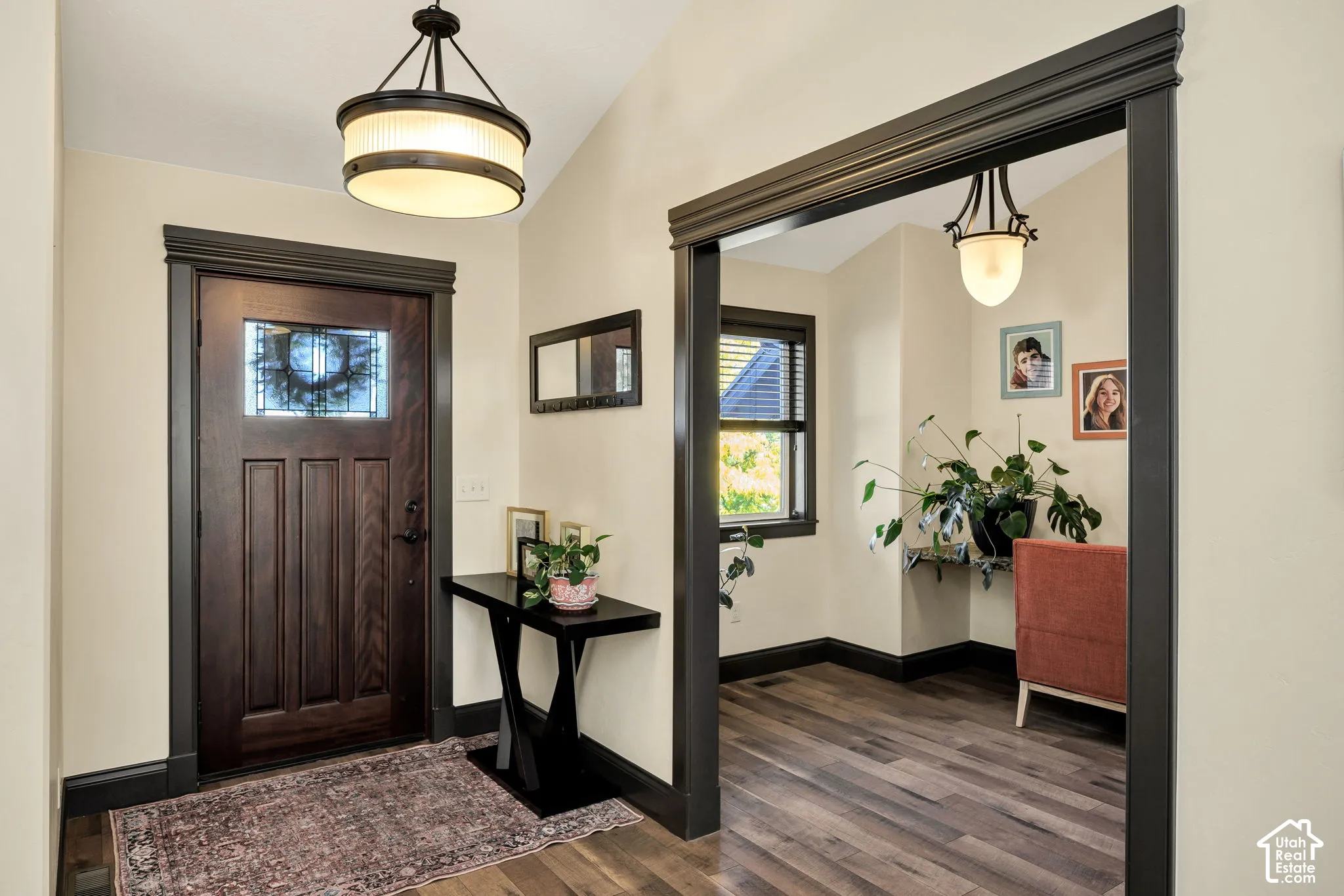 Hardwood-finish flooring, dark wood-paneled door with leaded glass insert, dark trim work, and recessed lighting fixtures