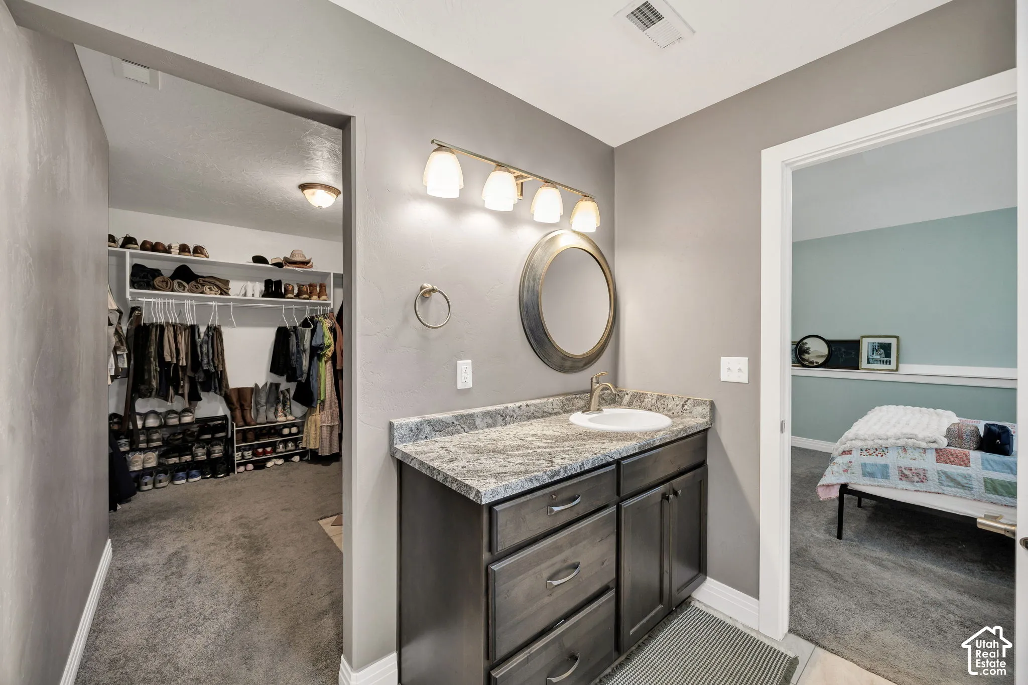 Vanity with a granite countertop, undermount sink, and wood-finish cabinetry
