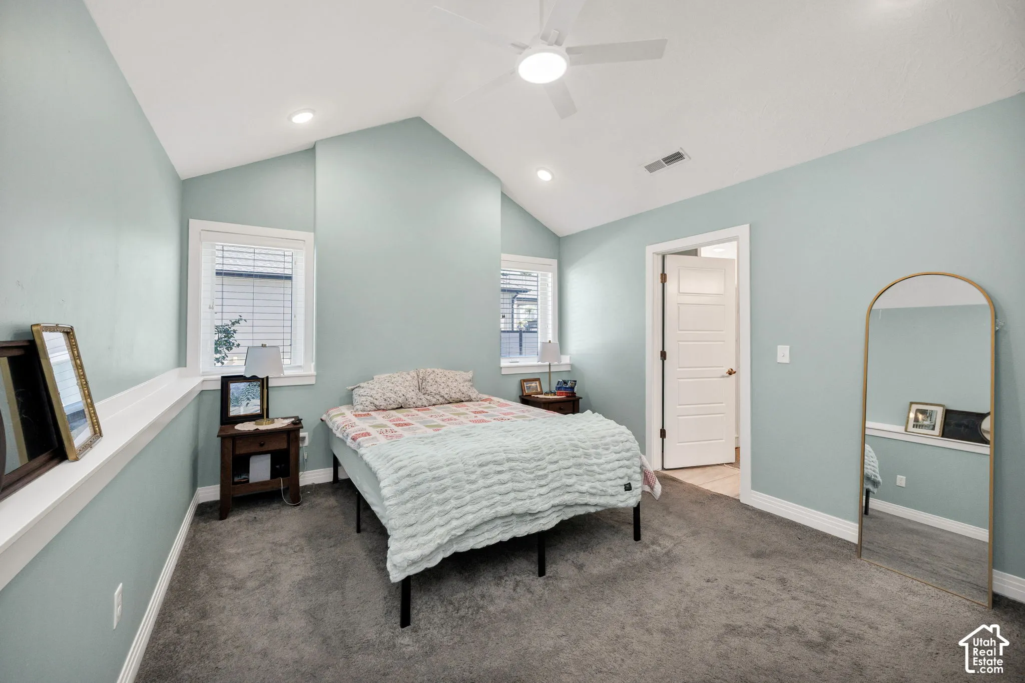 Vaulted ceiling with a ceiling fan, recessed lighting, carpet flooring, and multiple windows with blinds