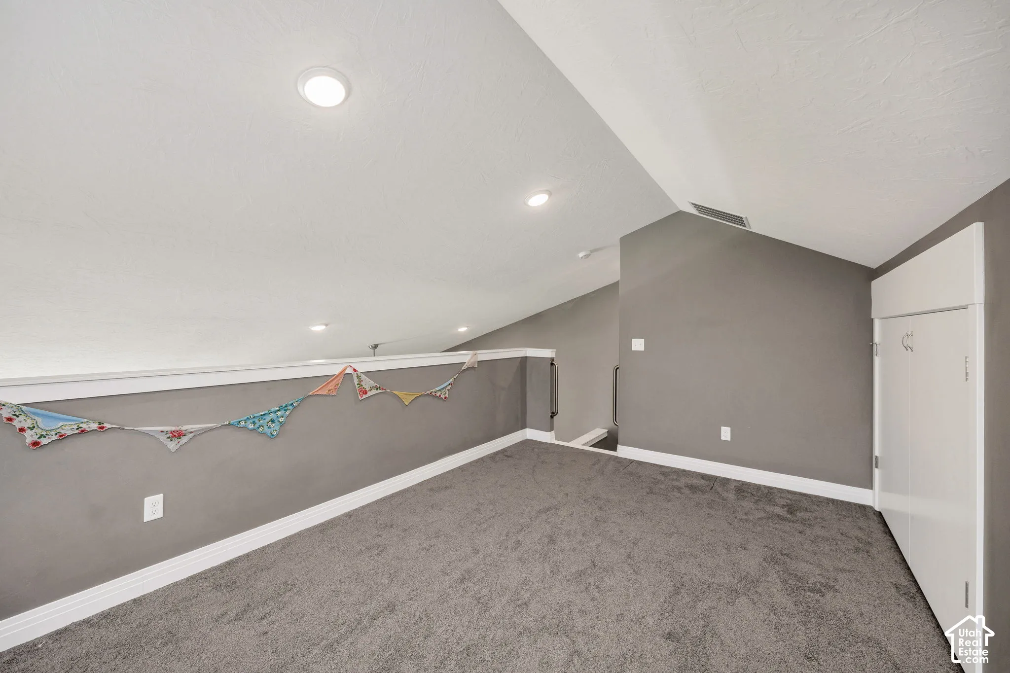 Recessed lighting, sloped ceiling, gray carpeting, gray wall paint, and white trim