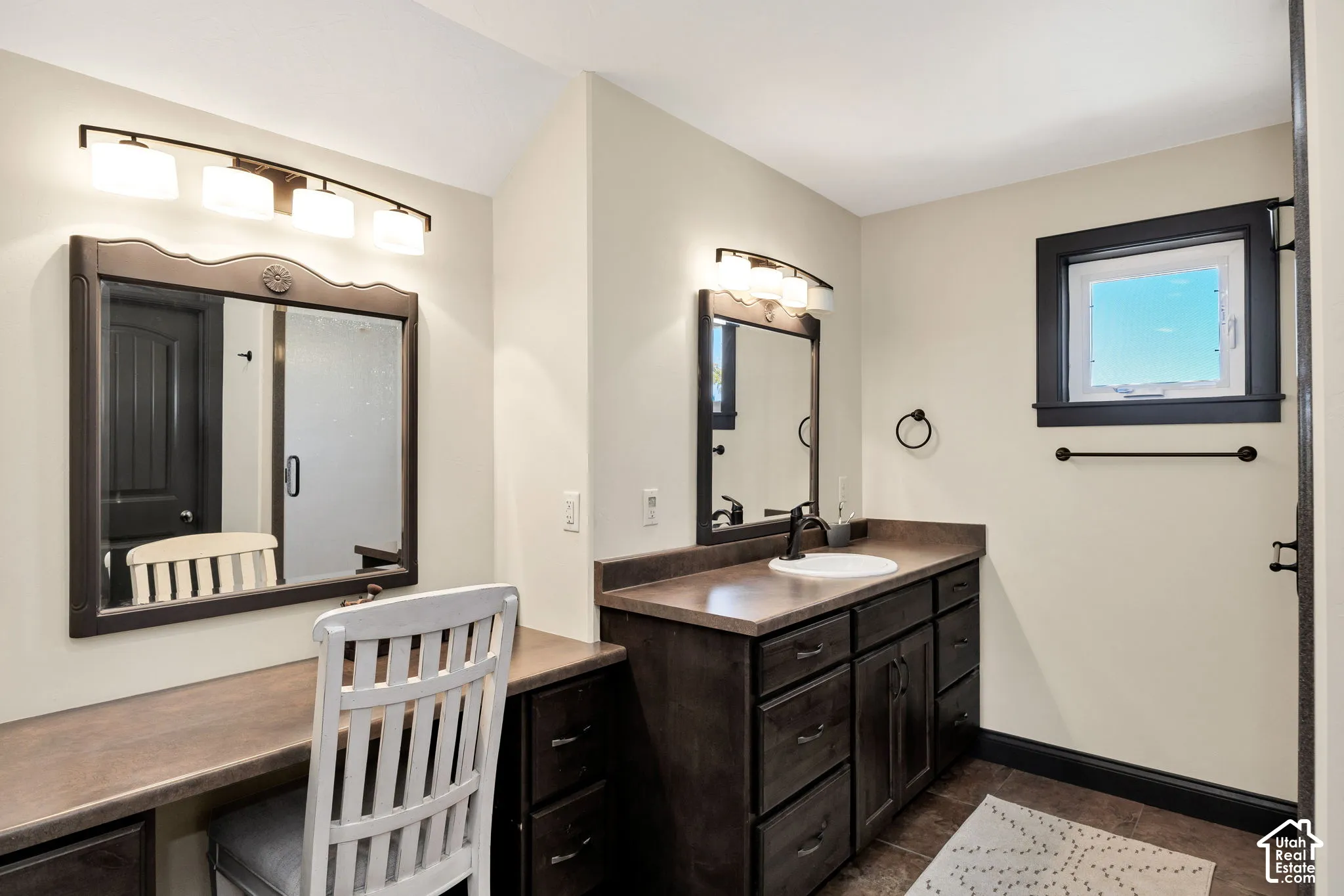 Dark wood-finish cabinetry with a built-in vanity, a single basin sink, and an integrated countertop
