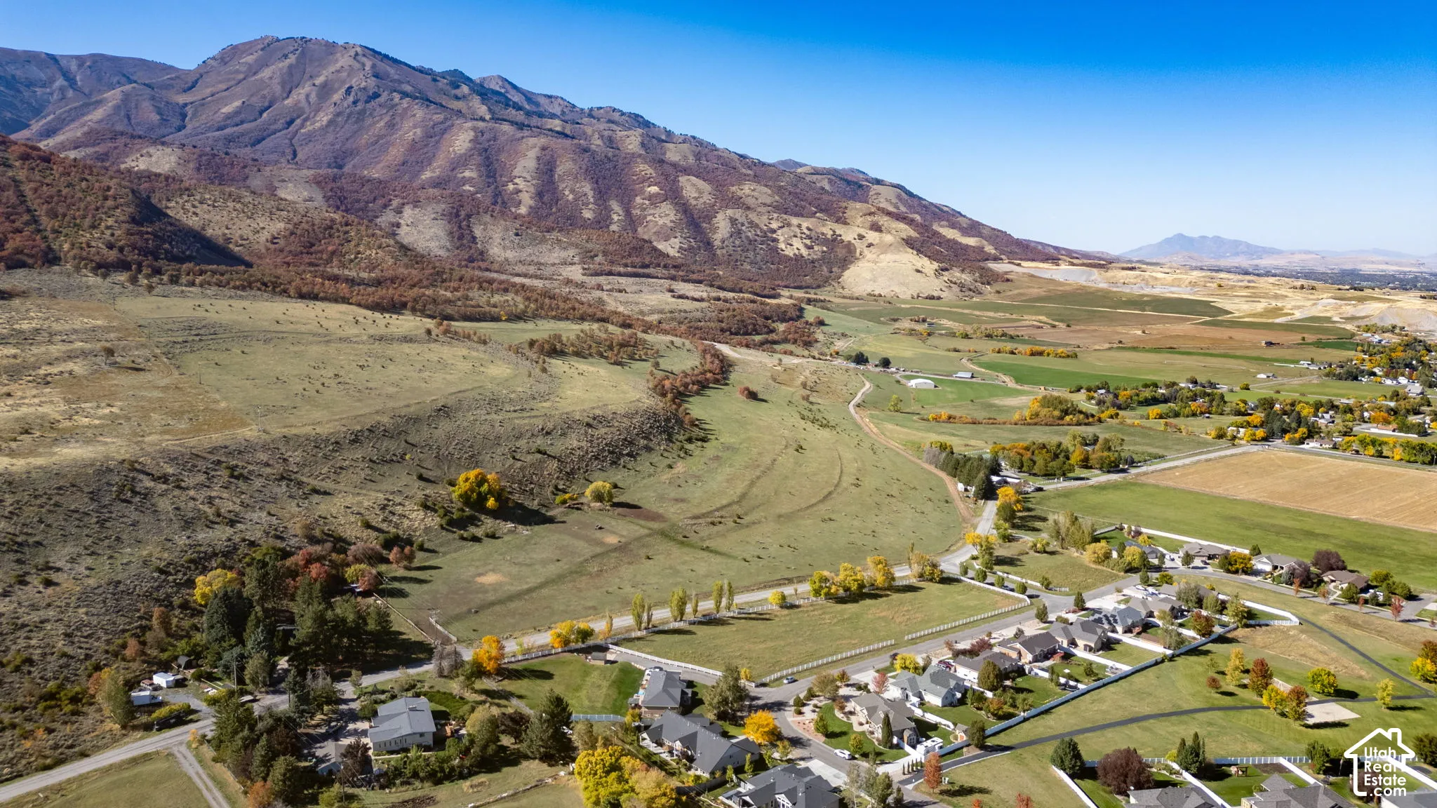 Scenic rural property overlooking expansive agricultural valley with manicured grounds, mature landscaping, and established residential neighborhood