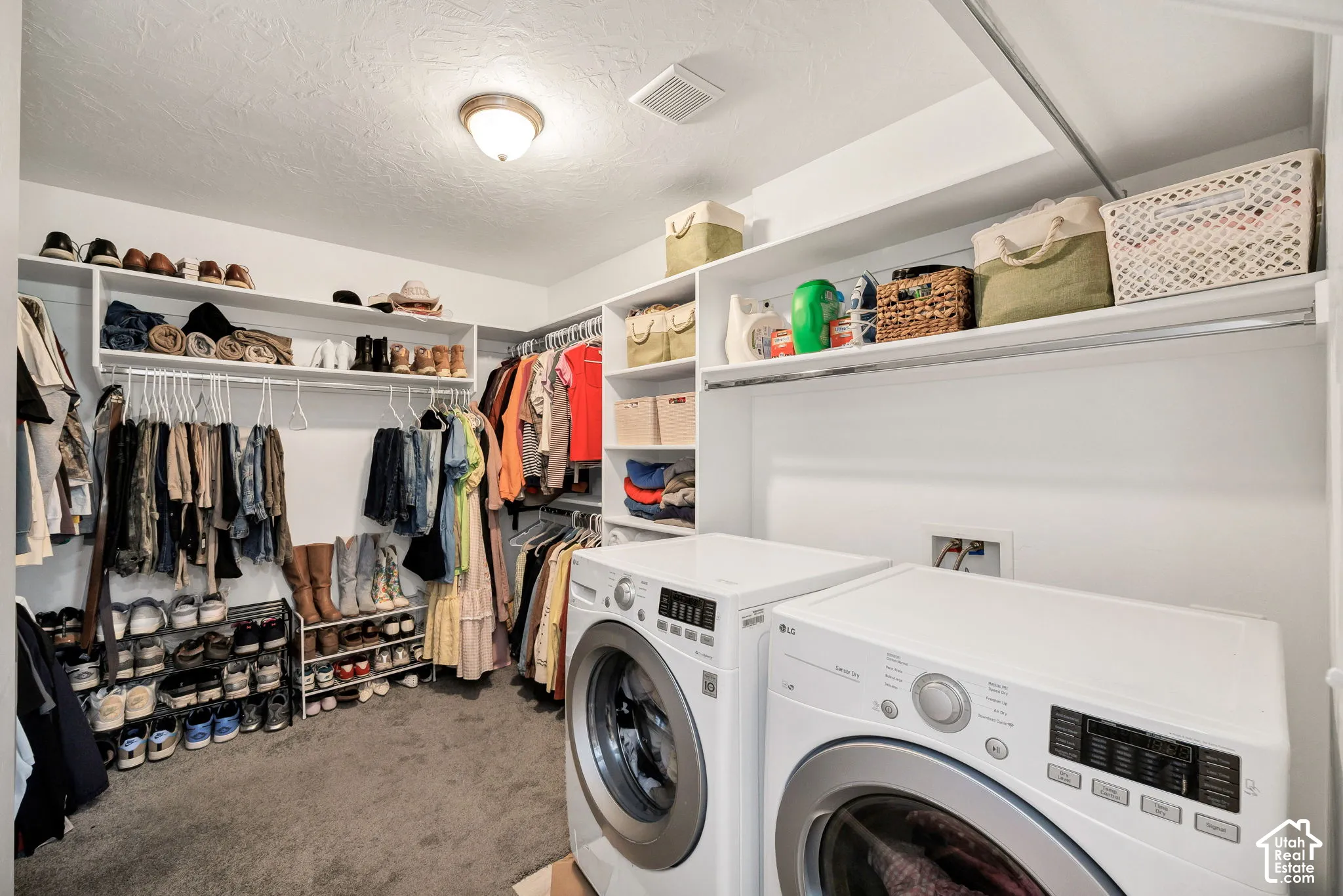 Built-in closet system featuring multiple shelves and hanging rods, accompanied by a laundry appliance hookup