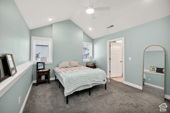 Vaulted ceiling with a ceiling fan, recessed lighting, carpet flooring, and multiple windows with blinds