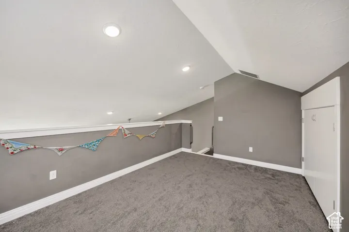 Recessed lighting, sloped ceiling, gray carpeting, gray wall paint, and white trim