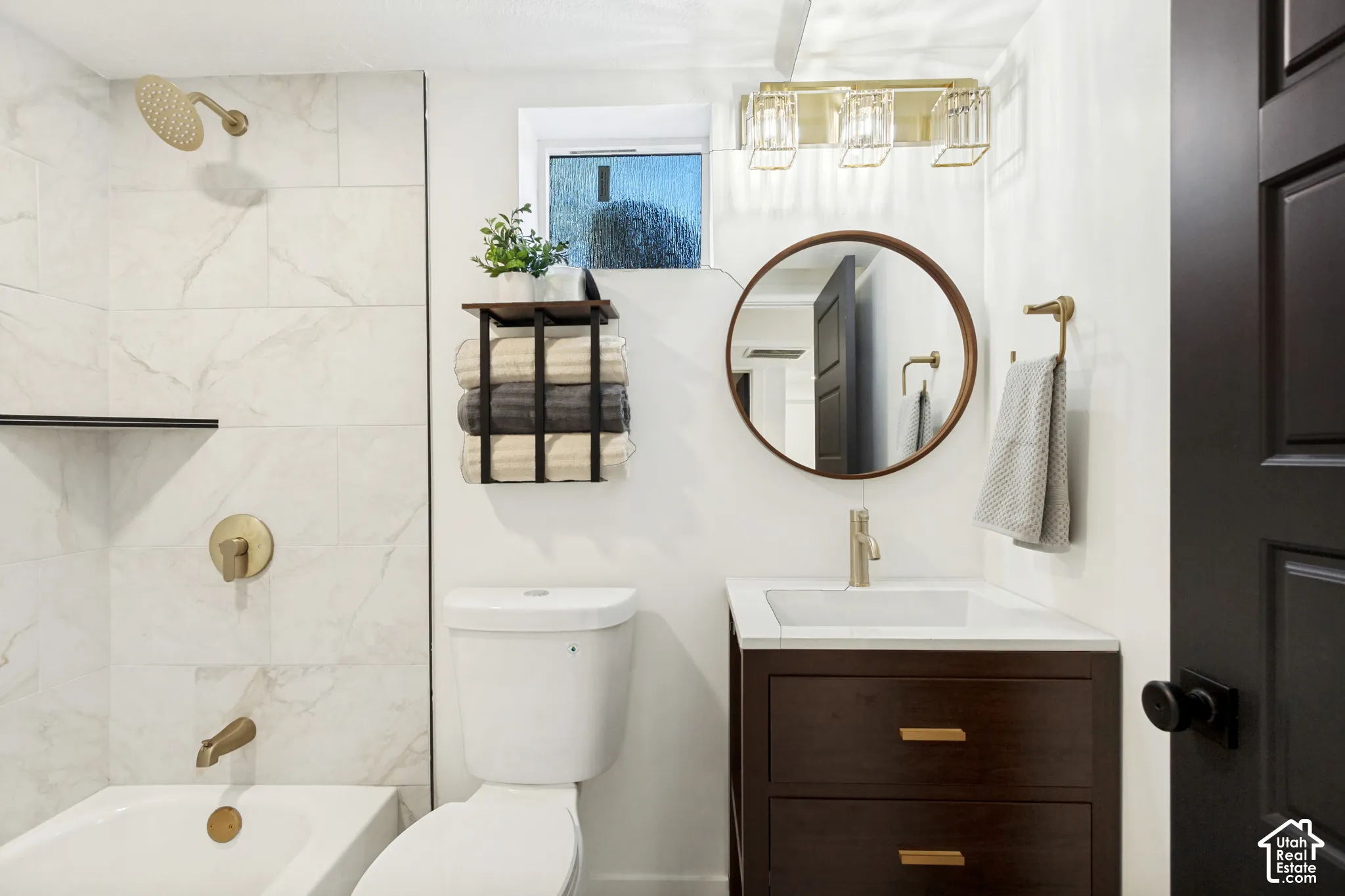 White subway tile shower surround with gold-finish fixtures