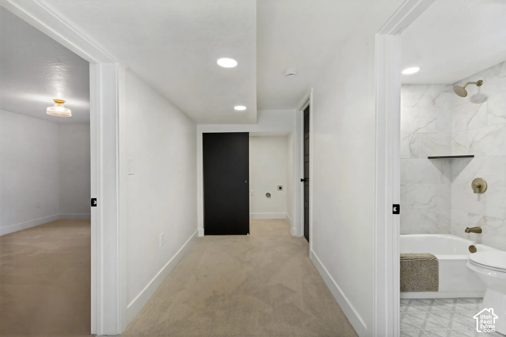 Recessed lighting, white walls, and carpeted flooring in the hallway