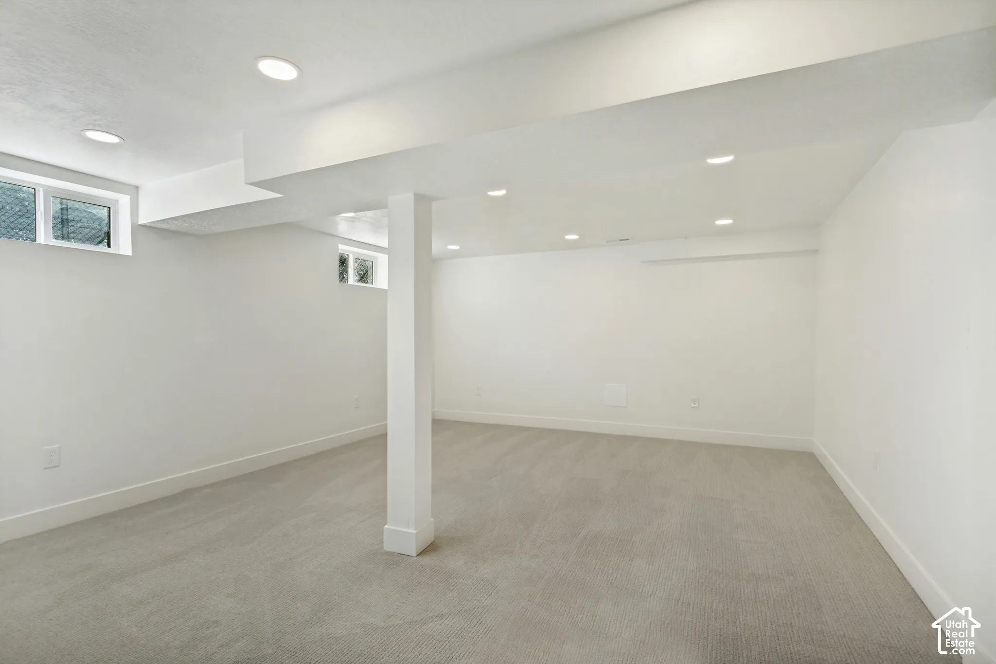 Recessed lighting, light gray carpeting, white walls, white ceiling, and two windows