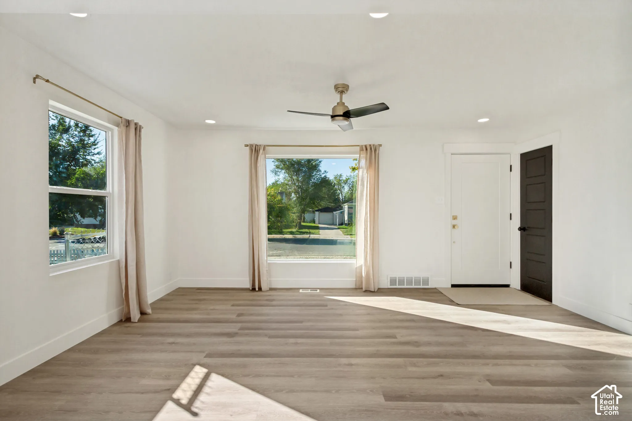 Wood-finish flooring, recessed lighting, and a ceiling fan with light fixture