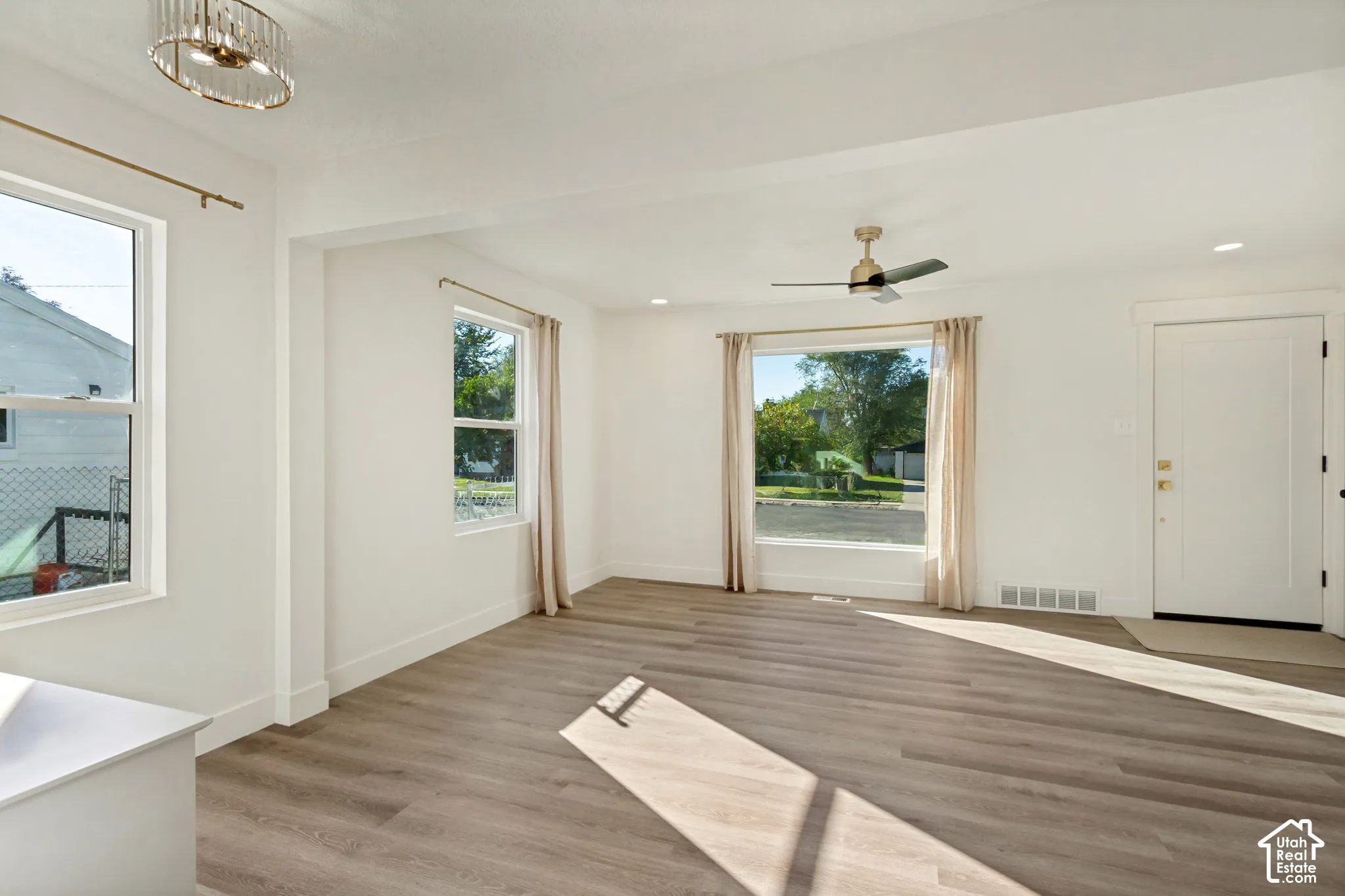 Wood-finish flooring, white walls, and recessed lighting