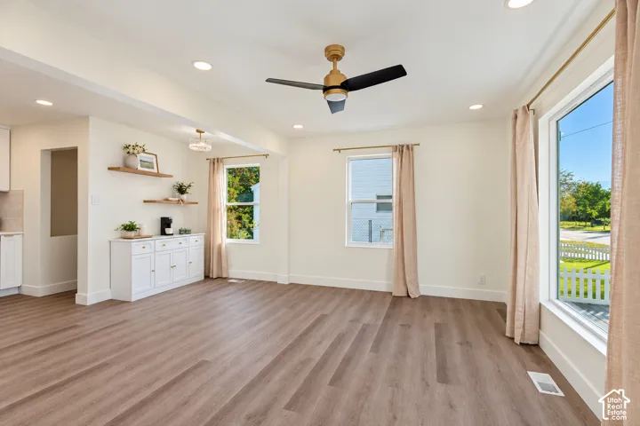 Spacious interior with wood-finish flooring, recessed lighting, and a modern ceiling fan