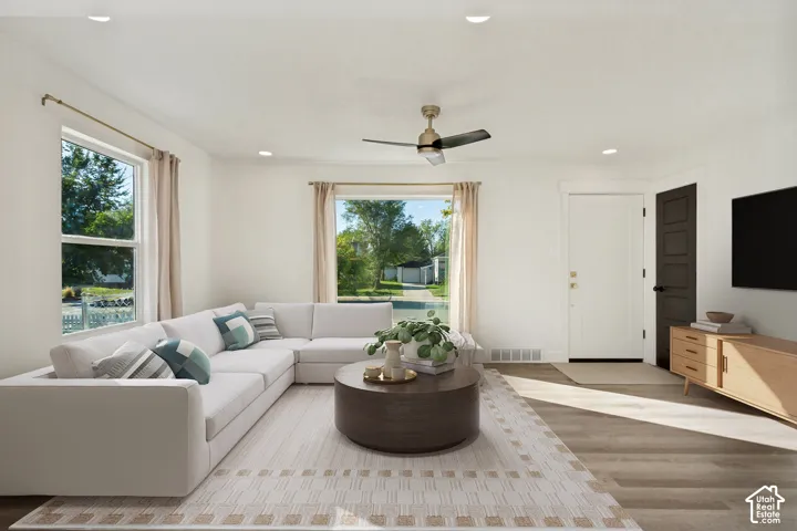 White walls with recessed lighting, wood-finish flooring, and a ceiling fan