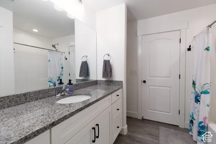 Vanity with a speckled countertop, undermount sink, and chrome faucet