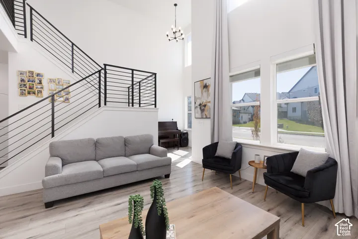Expansive living space featuring a two-story ceiling, large windows, and contemporary wood-finish flooring