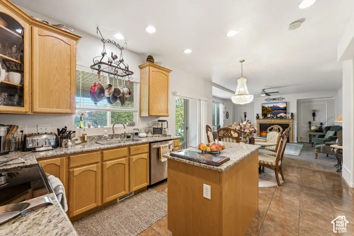 Kitchen featuring wood cabinetry, granite-style countertops, stainless steel appliances, and tile flooring