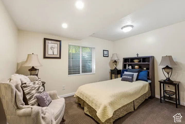 Recessed ceiling lighting, window with blinds, built-in headboard storage, and wall-to-wall carpeting