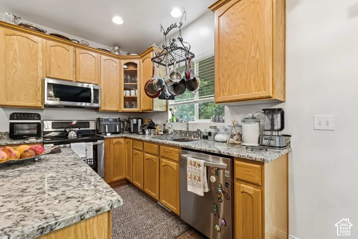 Kitchen featuring wood cabinetry, stainless steel appliances, and light-toned countertops