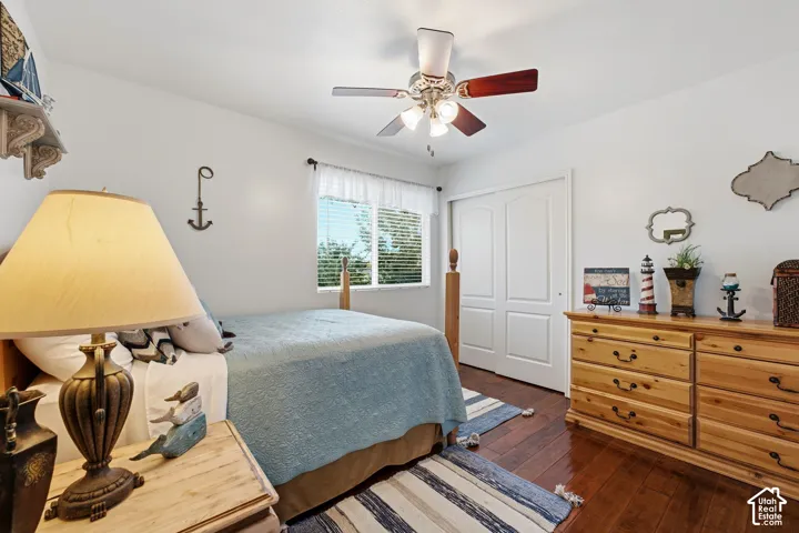 Hardwood-finish flooring with white walls and a ceiling fan with integrated lighting