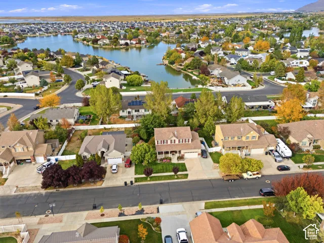 Residential neighborhood featuring a lake, mature trees, and paved roads