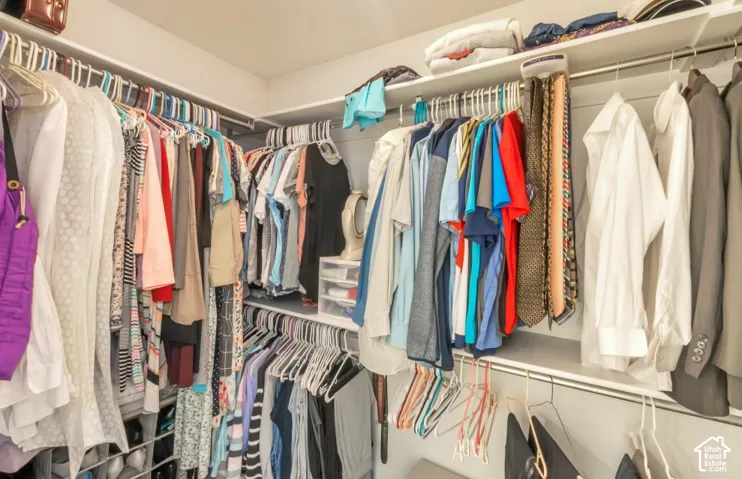 Built-in closet system with multiple hanging rods and integrated shelving for organized storage