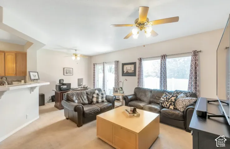 Spacious living area featuring neutral carpeting and multiple windows