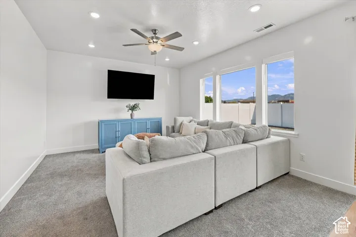Recessed lighting, ceiling fan, carpeted flooring, and a wall-mounted television