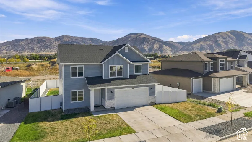 Two-story residence featuring light blue siding, a two-car garage, and a concrete driveway