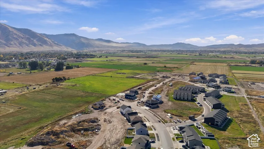 Expansive valley setting with agricultural fields, surrounded by distant mountains