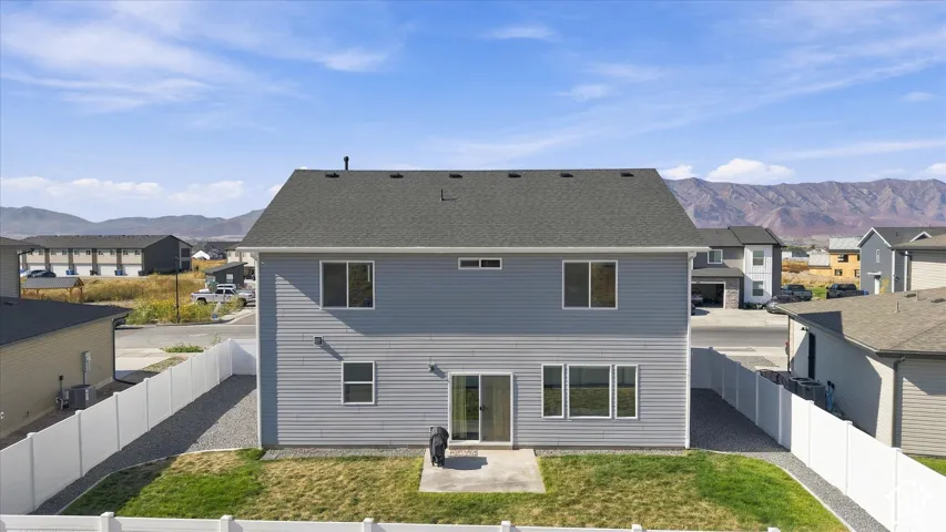 Two-story exterior with light gray siding, dark shingle roof, and multiple windows