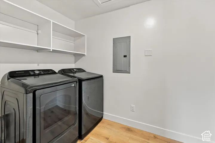 Laundry area featuring wood-finish flooring and white shelving