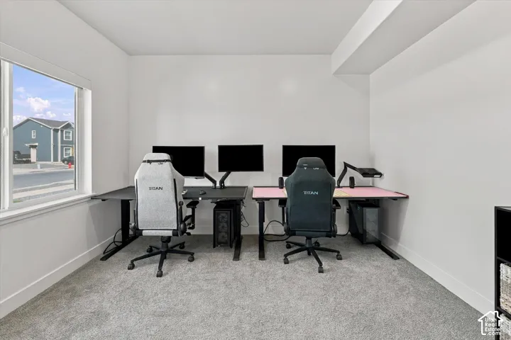 Recessed lighting, light gray carpet flooring, white painted walls, and a large window