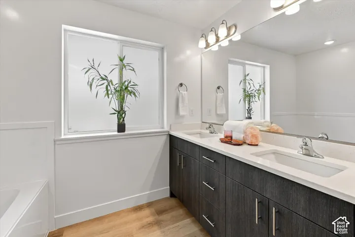 Dual vanity with undermount sinks, stone countertops, and dark wood-finish cabinetry
