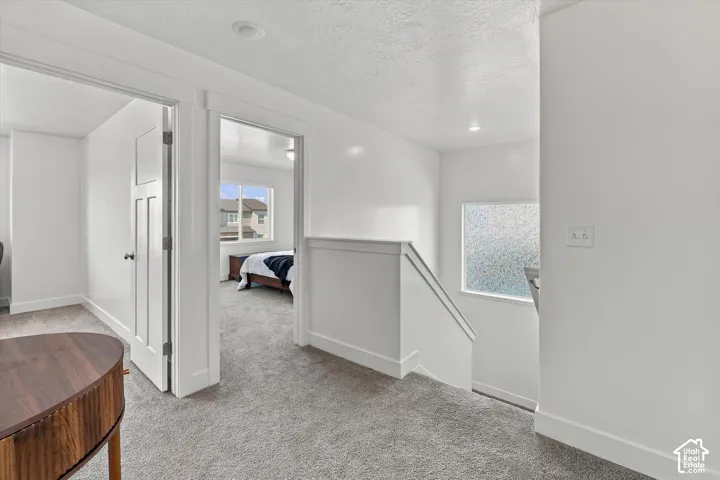 White painted walls, gray carpeting, recessed lighting, and white trim