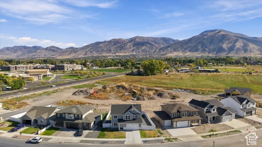 Mountain backdrop, residential development, paved streets, manicured lawns, two-story homes