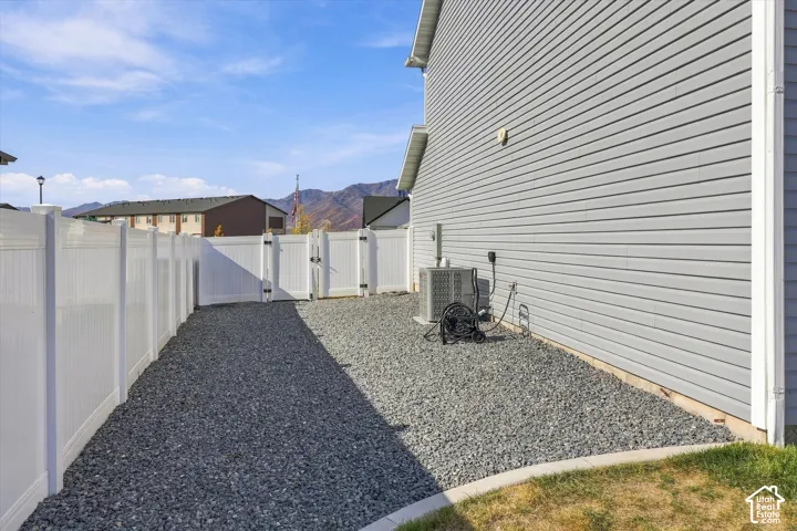 White vinyl fencing, gravel ground cover, and gray horizontal siding