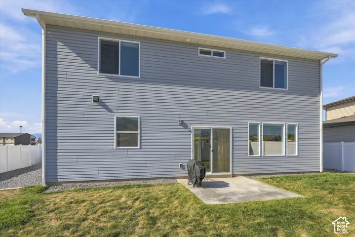 Light grey horizontal siding exterior with a concrete patio