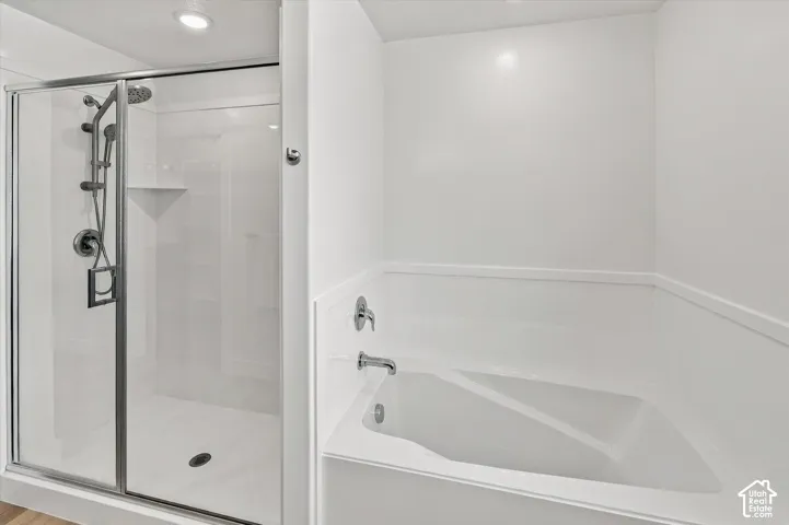 White-paneled shower with a glass enclosure and chrome fixtures