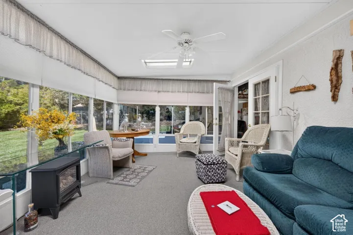 Sunroom featuring extensive window-lined walls, ceiling fan, recessed lighting, and French doors