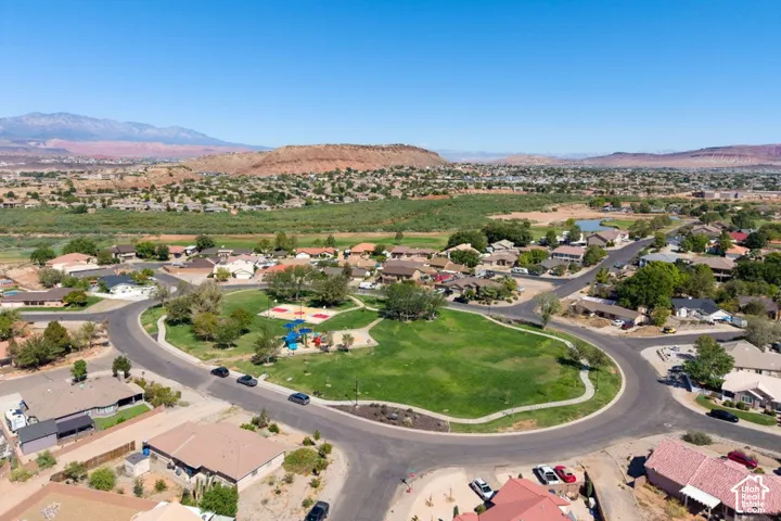 Residential neighborhood featuring a central park with playground, surrounded by curvilinear roads and mature trees