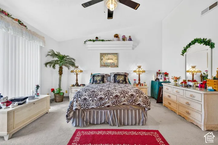 Vaulted ceiling with a ceiling fan, vertical blinds, and wall-mounted shelving