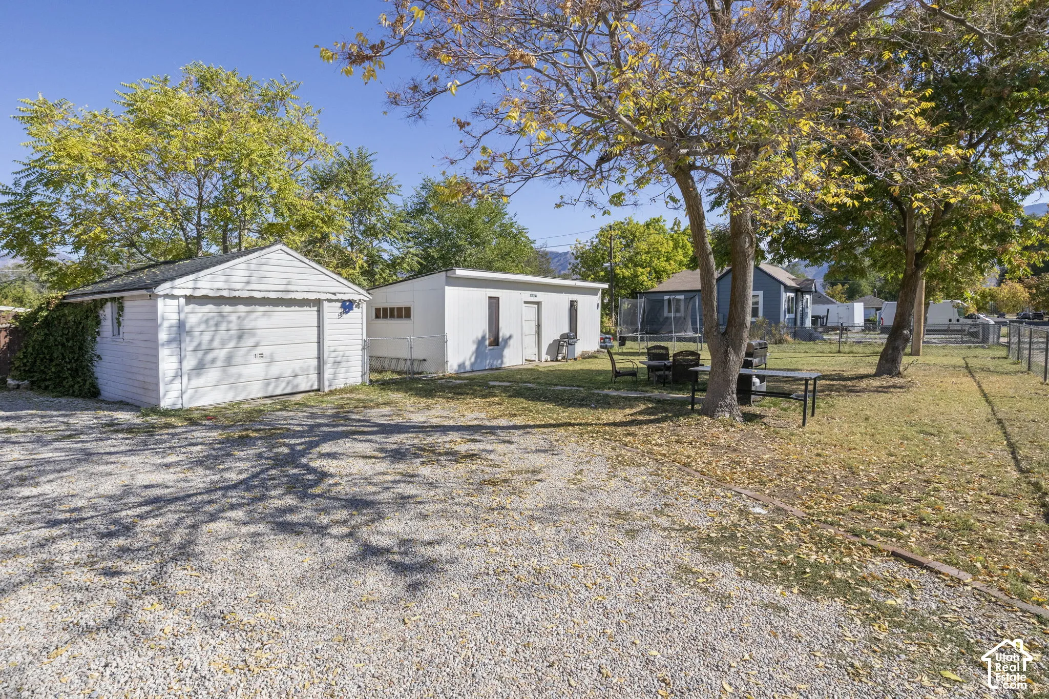 Detached garage and additional outbuilding with a gravel driveway