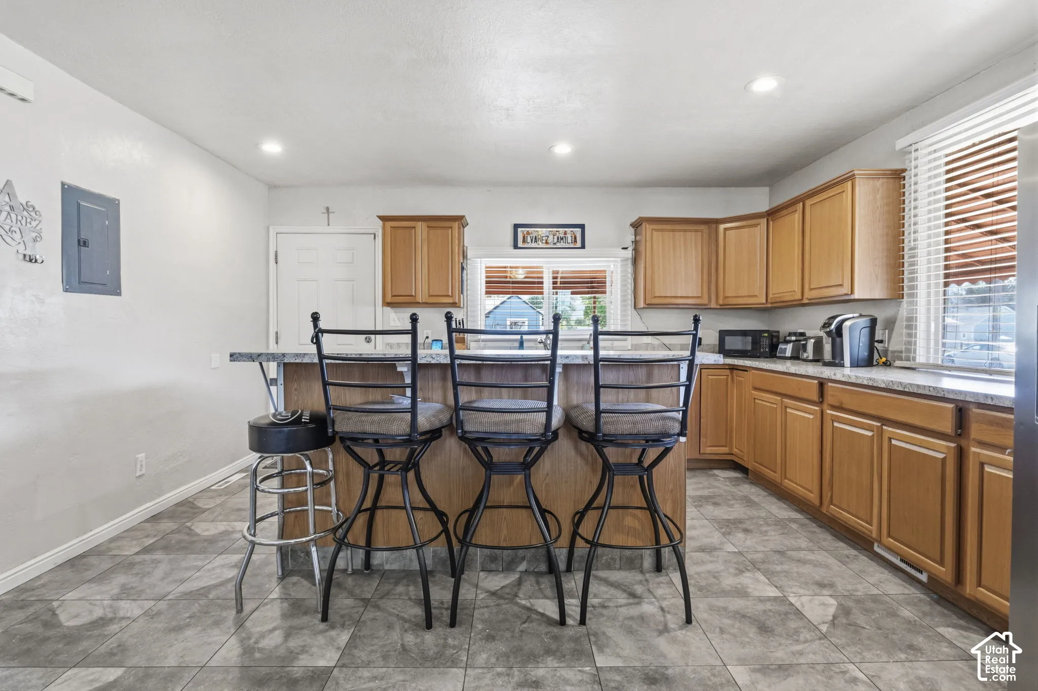 Kitchen featuring wood-finish cabinetry, a stone-finish countertop, and recessed lighting