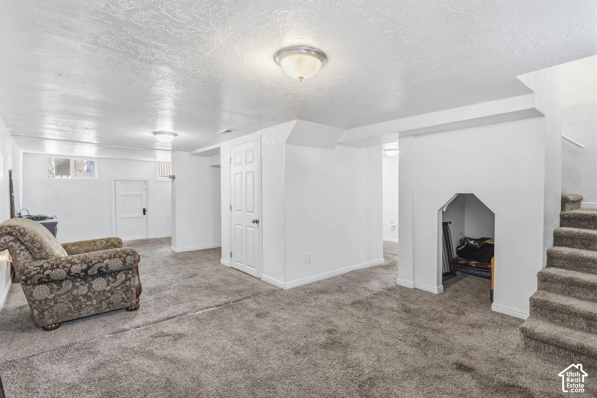 Carpeted flooring, recessed wall niche, interior doors, and overhead lighting