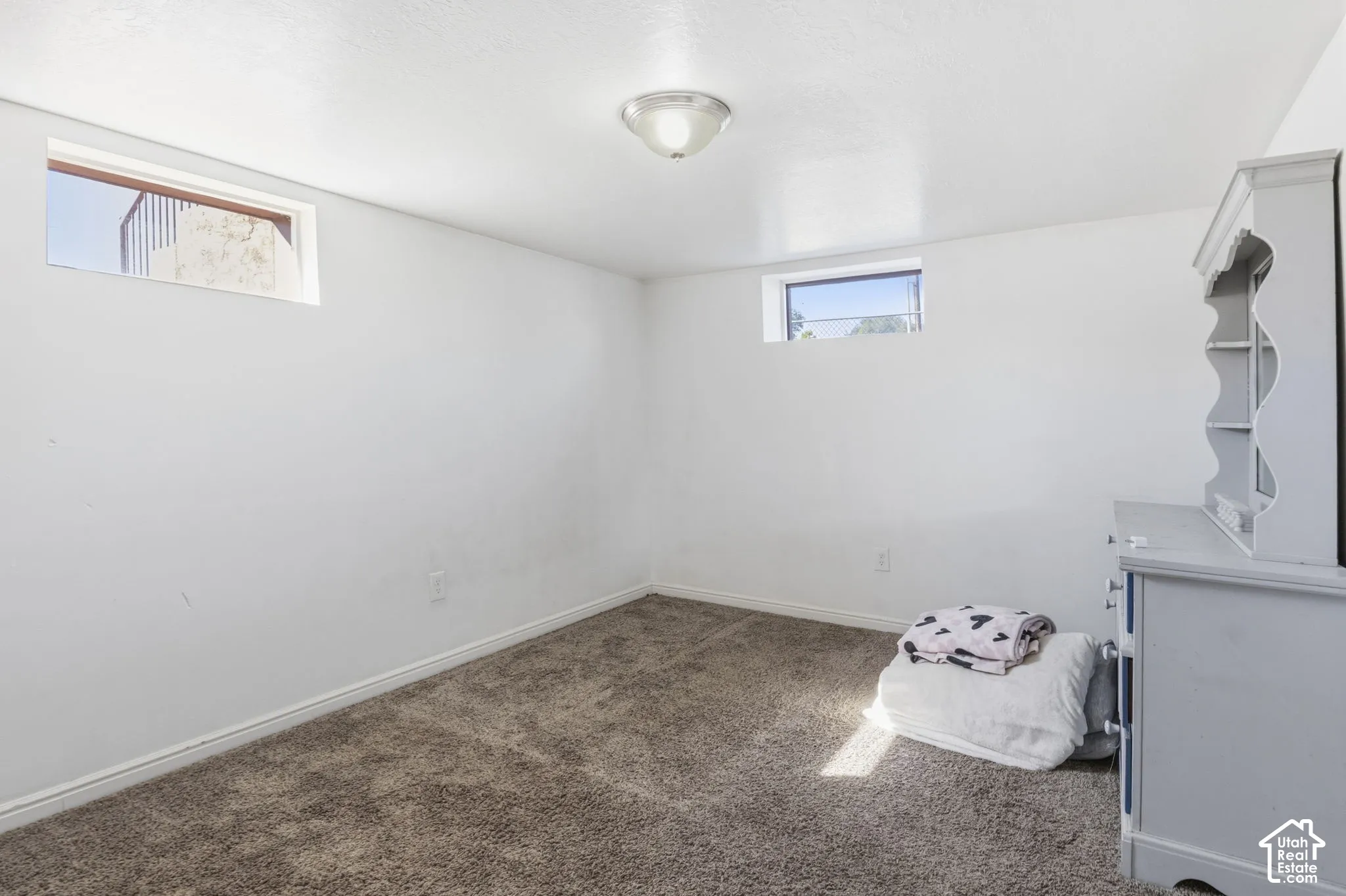 Neutral wall finishes, recessed window, and a ceiling-mounted light fixture