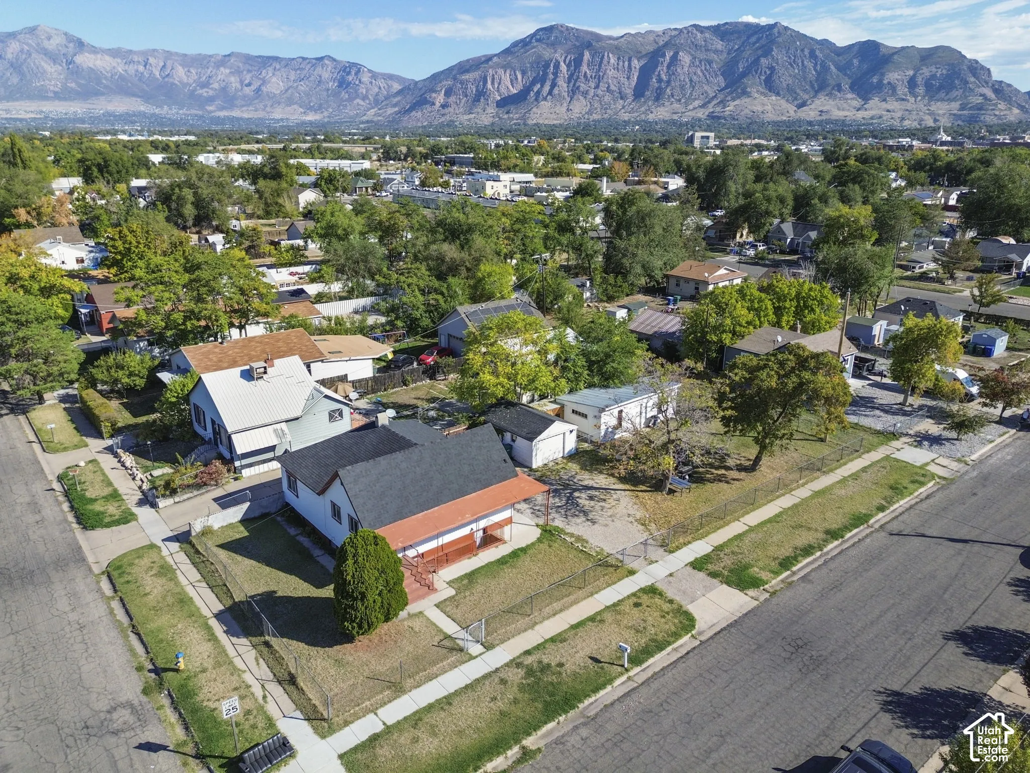 Residential neighborhood with mature trees and mountain backdrop