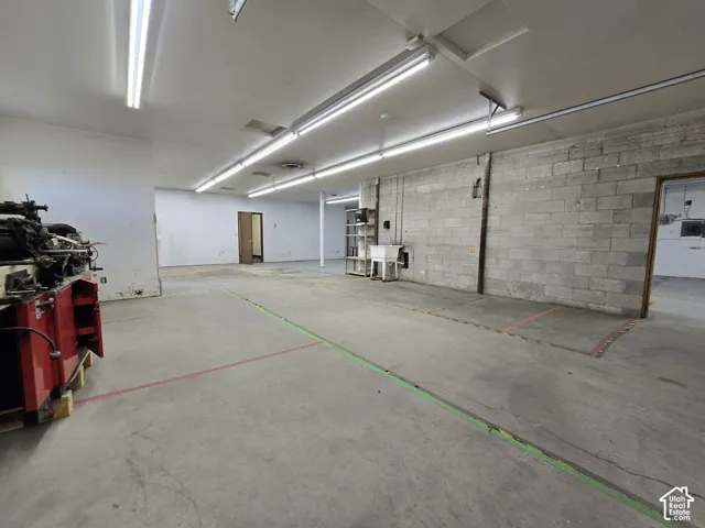 Concrete flooring, block wall construction, fluorescent lighting, built-in utility sink, multiple doorways
